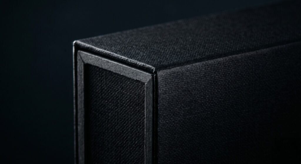 Macro close-up of a high-end custom rigid box edge, revealing thick 1200GSM board and textured specialty paper wrapping.