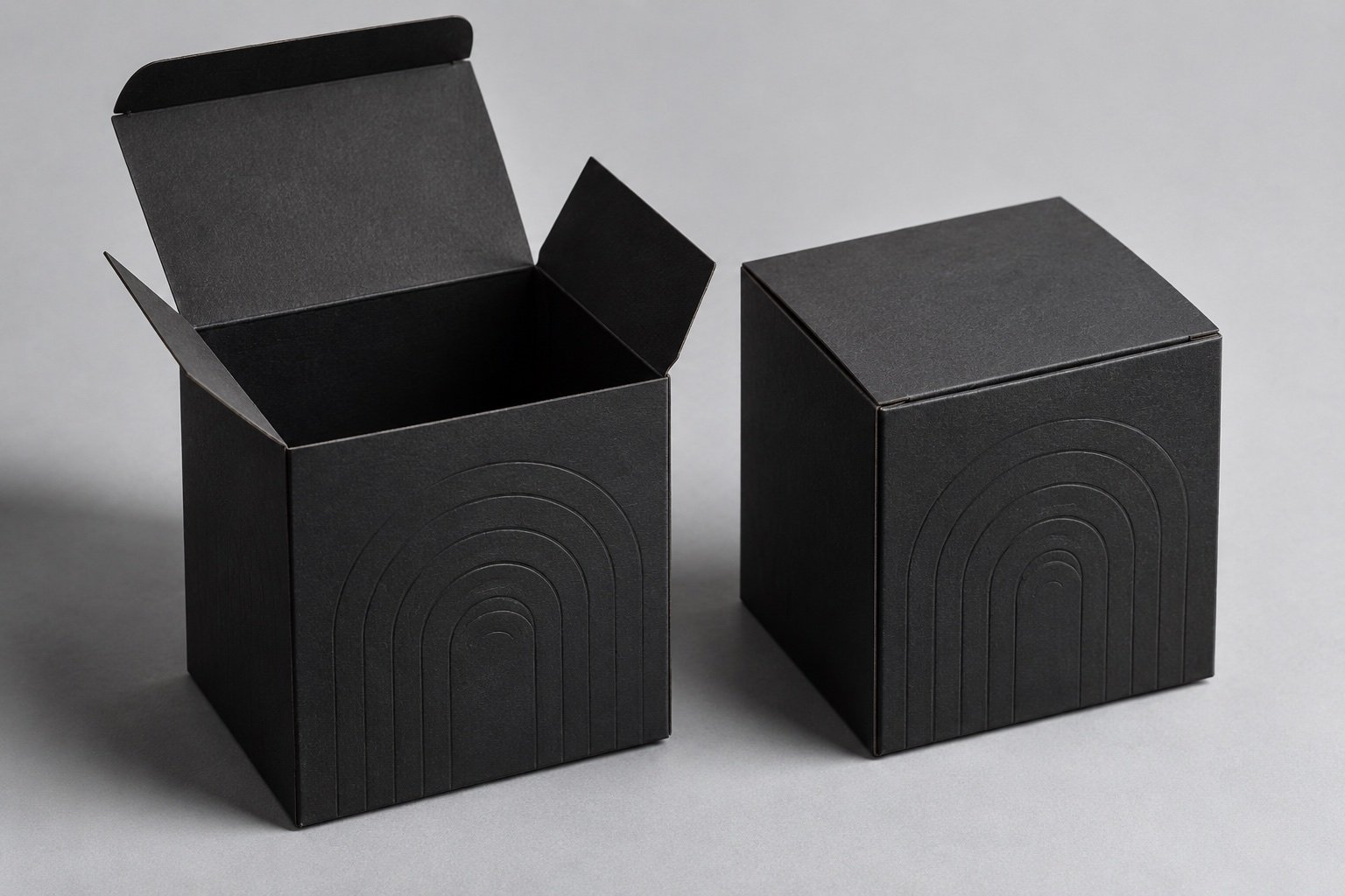 Open and closed charcoal folding cartons showing a tuck flap and embossed paperboard