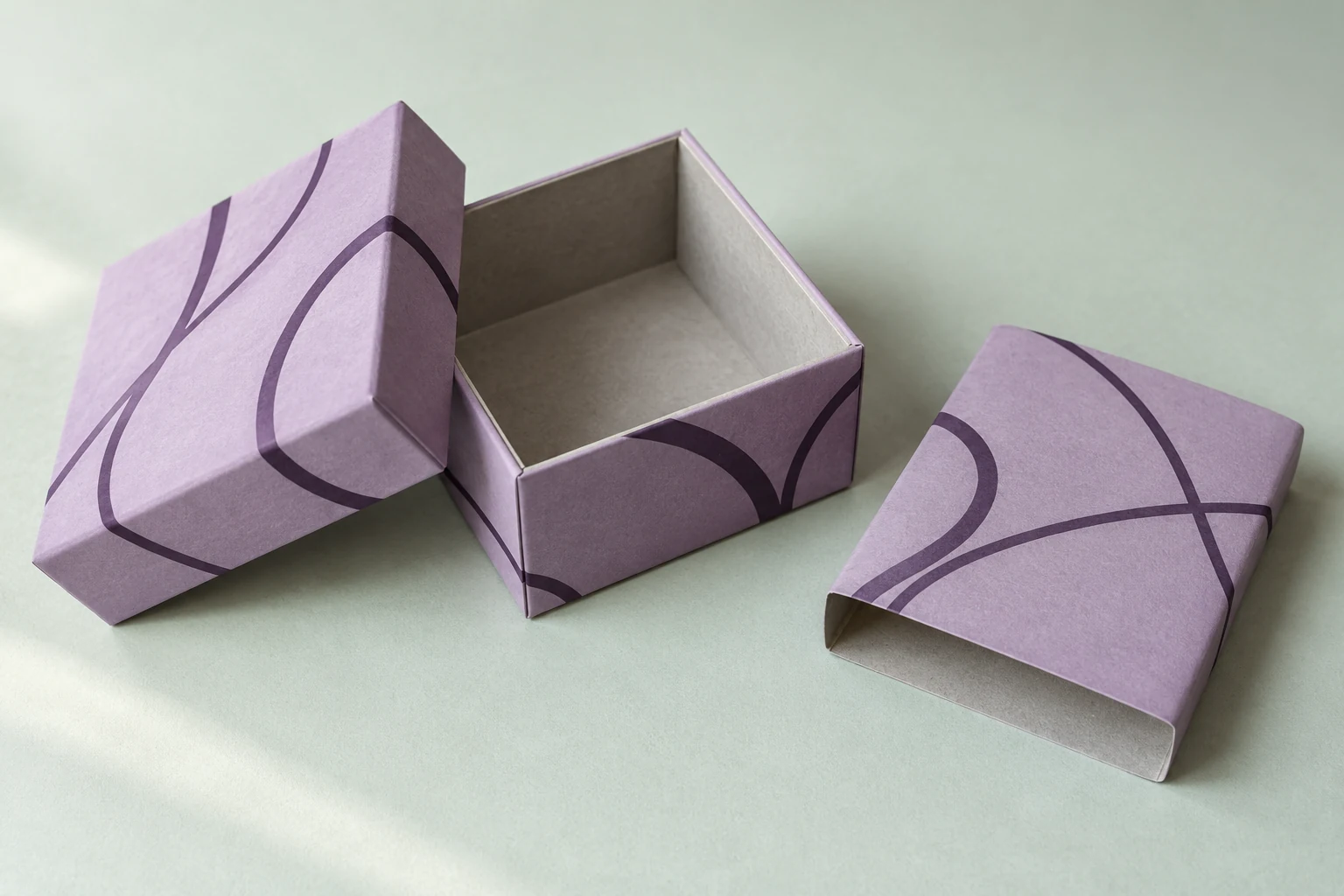 Illustrative lilac rigid gift box with a paper wrap around a thicker board core and a separate matching sleeve